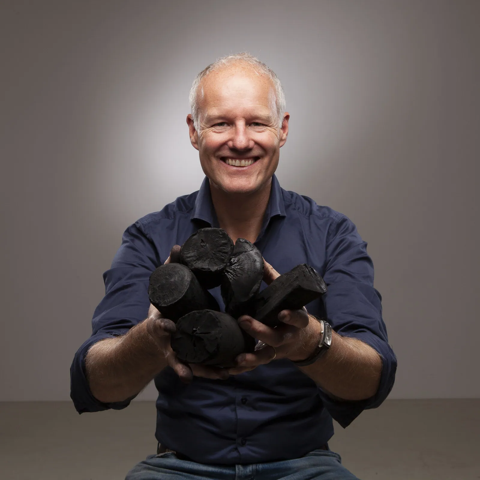 Laurens Simonis met een handvol grote stukken houtskool